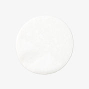 White round cotton pad with soft texture on a light gray background.