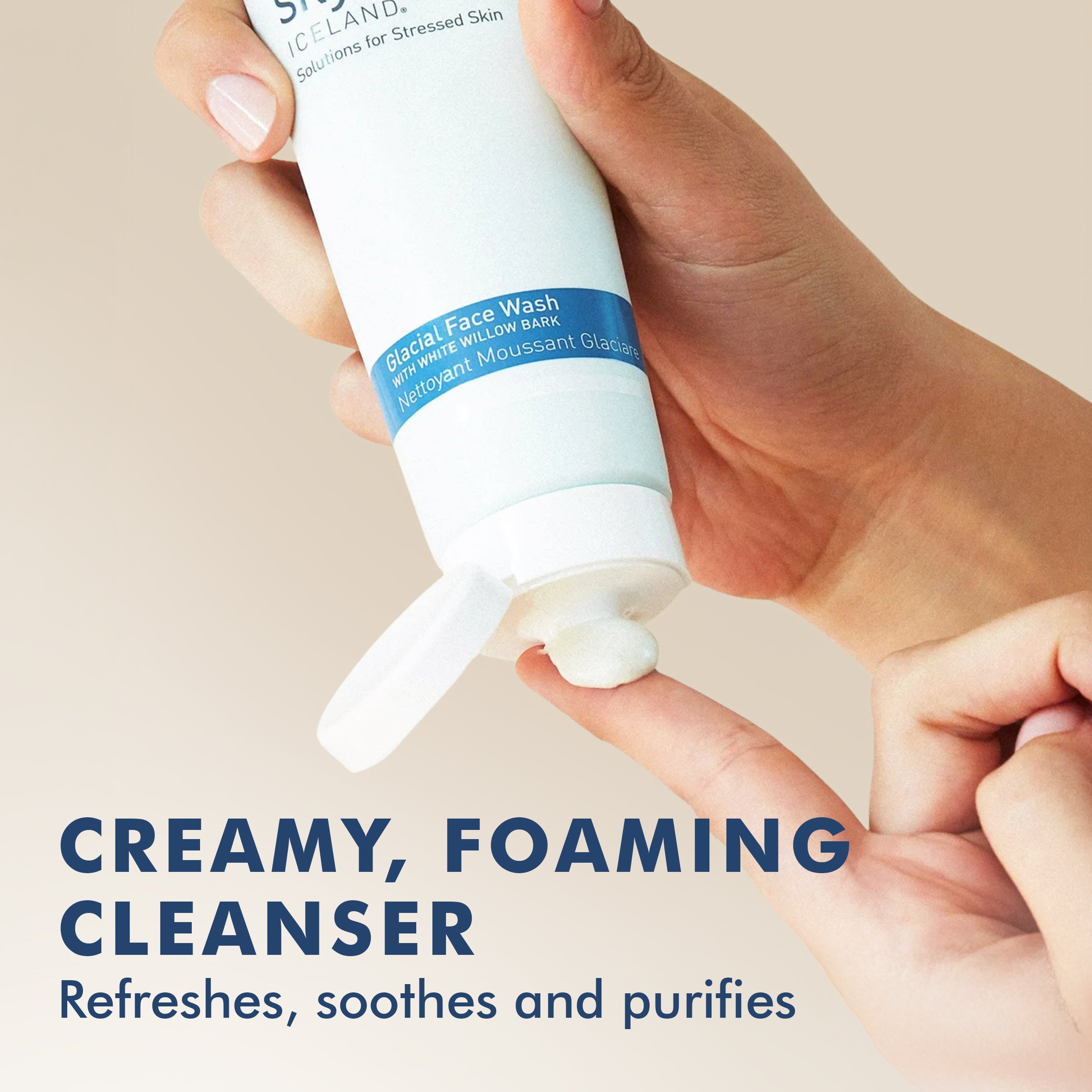 White and blue plastic tube of Glacial Face Wash with flip-top cap dispensing creamy cleanser on fingertip.