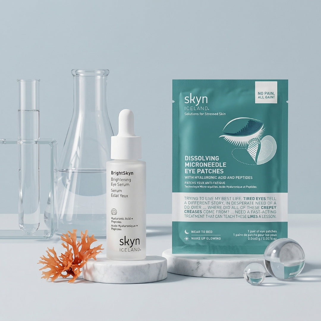 Pair of white and teal skyn eye patches and a white dropper serum bottle with clear laboratory glassware on a pale blue.